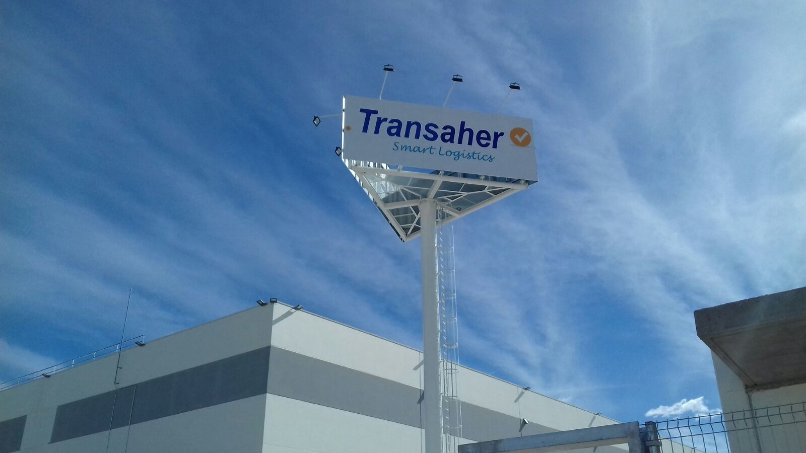 Monoposte publicitario de gran formato con iluminación superior, diseñado para máxima visibilidad de la marca Transaher en exteriores.