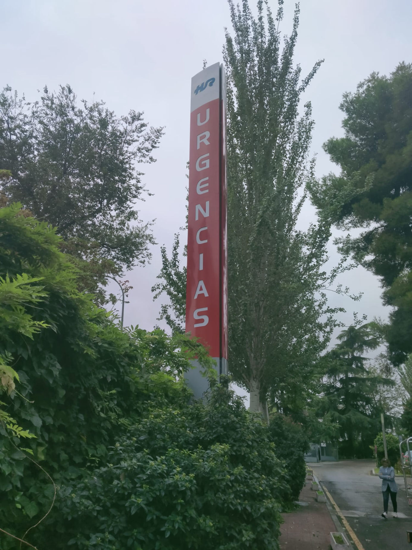 Poste publicitario retroiluminado con señalización vertical de 'Urgencias', diseñado para alta visibilidad en entornos hospitalarios.